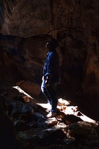 Rear view of man standing on rock