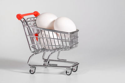 Eggs in a shopping cart, a close-up at the white background. a notion of shopping