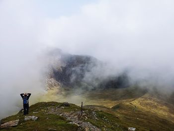 Man standing on rock against mountains