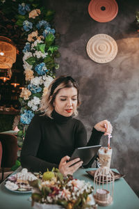 Young woman using mobile phone on table