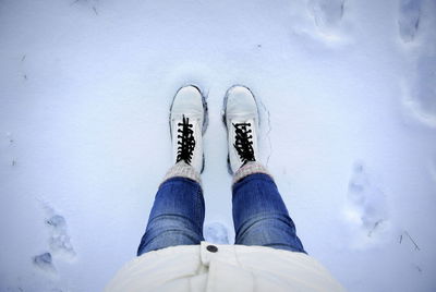 Low section of woman standing on snowcapped field