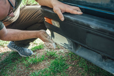 Low section of man holding umbrella