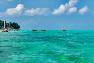 Sailboats in sea against sky