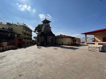 Statue amidst buildings in city against sky