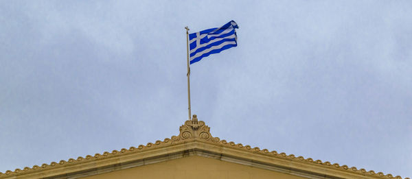 Low angle view of flag building against sky