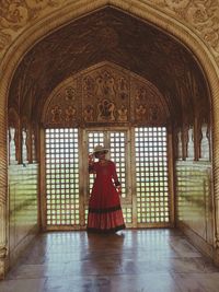 Rear view of woman walking in temple building