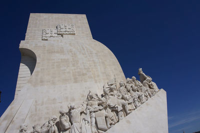 Low angle view of statue against blue sky padrao dos descobrimentos, lisbon, portugal