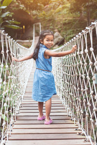 Full length portrait of girl walking on footbridge