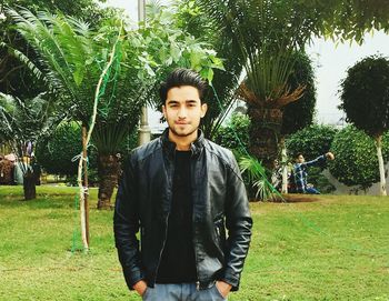 Portrait of young man standing against plants