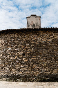 Low angle view of old building against cloudy sky