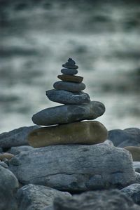 Stack of stones on rocks at shore