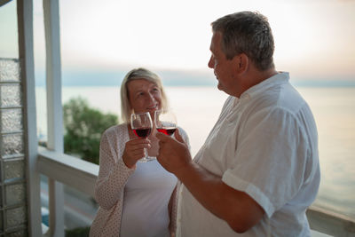 Mature couple drinking wine outdoors 