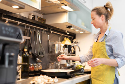 Mid adult woman standing in kitchen