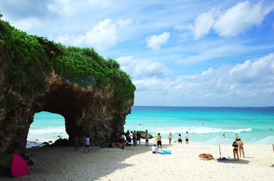 People at beach against sky