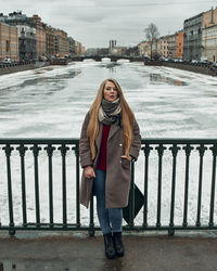 Full length of woman standing on railing during winter