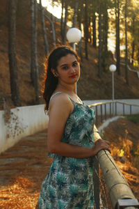 Side view of woman standing by railing