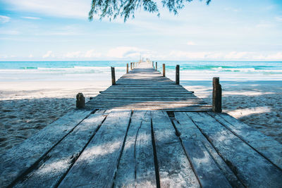 Wooden pier on sea shore against sky