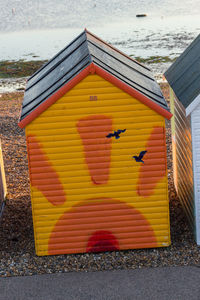 Close-up of yellow umbrella on street by building