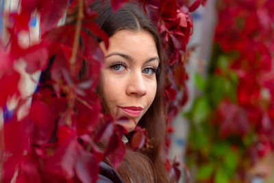 Portrait of young woman with red leaves