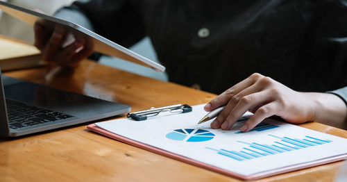 Midsection of man using laptop on table