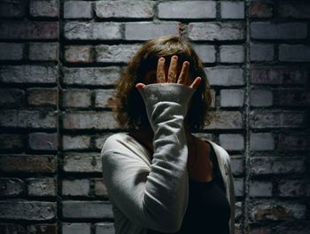 Woman standing against brick wall