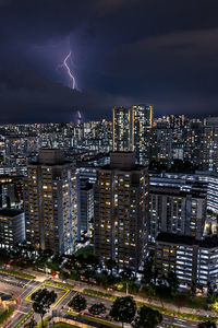 Illuminated cityscape against sky at night