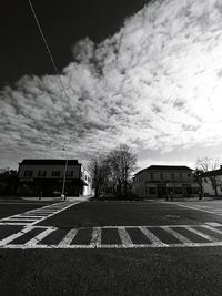 Cars on road against sky in city