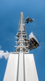 Low angle view of communications tower against blue sky