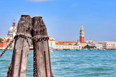 View of sea and buildings against blue sky