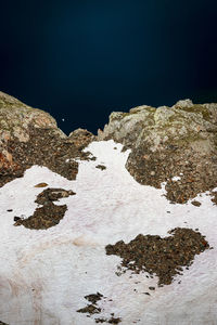 Rock formations on sea shore against sky