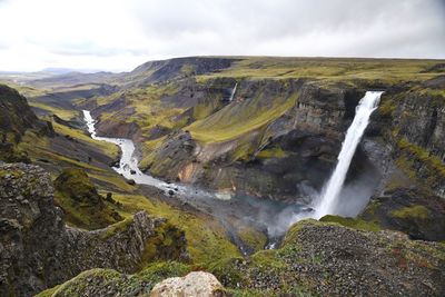 Scenic view of waterfall against sky