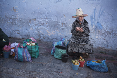 Woman sitting in basket on wall