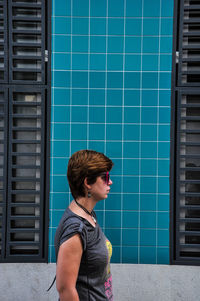Side view of man standing against building