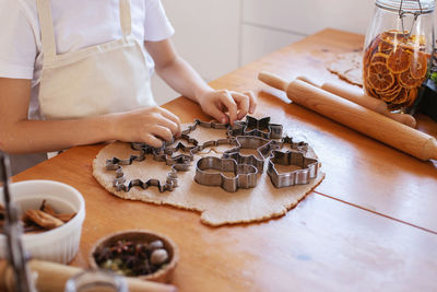 Children with their mother cut out christmas gingerbread cookies . family holiday cooking.