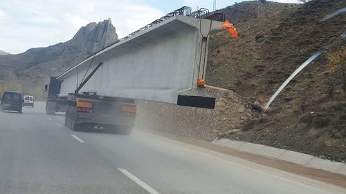 Road by mountain against sky