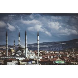 View of cityscape against cloudy sky