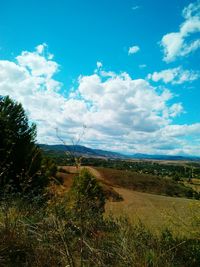 Scenic view of field against cloudy sky