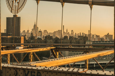 View of bridge and buildings against sky during sunset