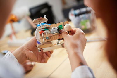 Cropped image of multi-ethnic female technicians making model at workshop