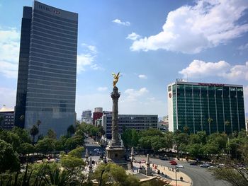 Statue of city buildings against cloudy sky