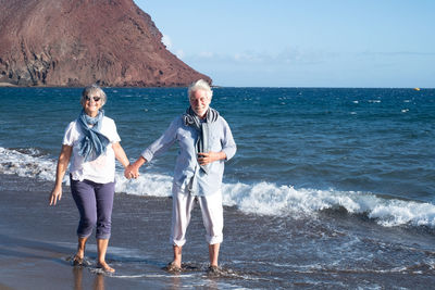Senior couple holding hands at beach