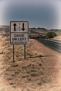 Information sign on road against sky