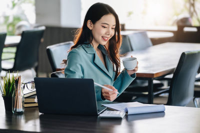 Businesswoman using laptop at office