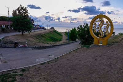 Bicycle by road against sky in city