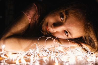 Close-up portrait of cute girl by illuminated lights