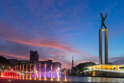 Statue of illuminated building against sky at night