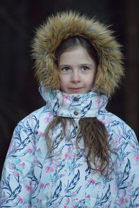 Cute girl in warm clothing against black background