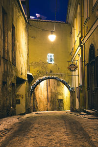 Illuminated street amidst buildings in city at night