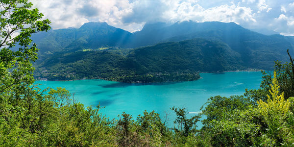 Scenic view of sea and mountains against sky