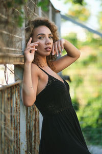 Portrait of beautiful young woman standing against blurred background